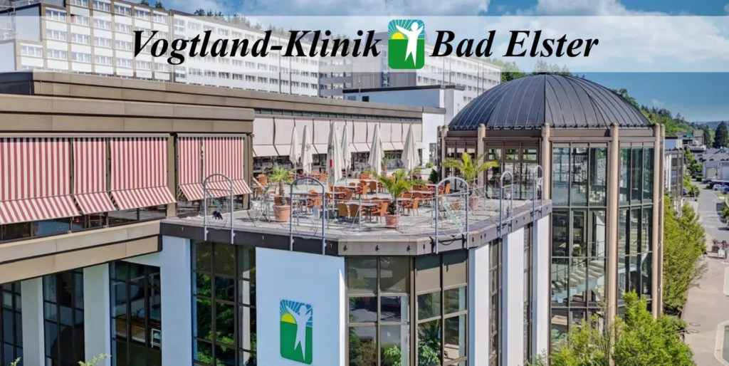 Eine Außenansicht der Vogtland-Klinik Bad Elster mit einem Restaurantbereich auf dem Dach.